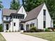 A stunning white brick home with gray trim, a two-car garage, and a well-manicured front yard with a concrete driveway at 602 Shelley Rd, Raleigh, NC 27609