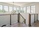 Bright foyer with large windows, wooden railing and staircase featuring an eye-catching geometric light fixture at 602 Shelley Rd, Raleigh, NC 27609