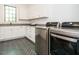 Bright laundry room featuring shaker cabinets, dark countertops, modern washer and dryer, and herringbone tile floors at 602 Shelley Rd, Raleigh, NC 27609