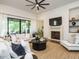 Spacious living room with a fireplace, large windows, modern ceiling fan, and comfortable furnishings at 602 Shelley Rd, Raleigh, NC 27609