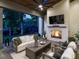 Cozy outdoor living space with fireplace, comfortable seating, ceiling fan and view to backyard at 602 Shelley Rd, Raleigh, NC 27609
