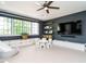 Spacious playroom with dark blue walls, storage cabinets, floating shelves, and a ceiling fan at 602 Shelley Rd, Raleigh, NC 27609