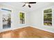 Well-lit bedroom with hardwood floors, large windows, ceiling fan and an exterior door to a deck at 607 Smedes Place # B, Raleigh, NC 27605