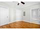 Bedroom features hardwood floors, a ceiling fan, and doors leading to other rooms or bathrooms at 607 Smedes Place # B, Raleigh, NC 27605