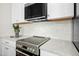 Close-up of a modern kitchen featuring stainless steel appliances, marble countertops, and white backsplash at 607 Smedes Place # B, Raleigh, NC 27605