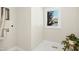 Functional laundry room with white tile floors, a window, and connections for a washer and dryer at 607 Smedes Place # B, Raleigh, NC 27605