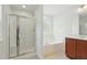 Bathroom featuring tiled floor, glass shower and soaking tub under window at 704 Moonbeam Dr, Raleigh, NC 27603