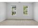 A bedroom showcases two windows, neutral carpet, and white walls at 704 Moonbeam Dr, Raleigh, NC 27603
