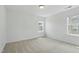Bedroom featuring two windows providing natural light and neutral carpet at 704 Moonbeam Dr, Raleigh, NC 27603