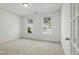 Bedroom with carpet, two windows offering neighborhood views, and white walls at 704 Moonbeam Dr, Raleigh, NC 27603