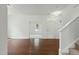 Bright living room featuring hardwood floors, white walls, and an open entryway at 704 Moonbeam Dr, Raleigh, NC 27603