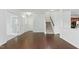 Spacious living room with hardwood floors, open staircase, and bright white walls at 704 Moonbeam Dr, Raleigh, NC 27603