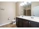 A full bathroom with dual sinks, dark cabinetry, and a glass-enclosed shower at 7229 Terregles Dr, Raleigh, NC 27617