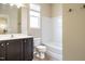 Bright bathroom featuring a vanity with dark cabinets, a toilet, and a shower-tub combo with white walls at 7229 Terregles Dr, Raleigh, NC 27617