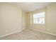 A bedroom featuring beige walls, carpeted floors, and a window with shutters at 7229 Terregles Dr, Raleigh, NC 27617