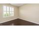 A bedroom with a window featuring white shutters and hardwood floors at 7229 Terregles Dr, Raleigh, NC 27617