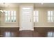 Bright foyer with hardwood floors, white door, and windows with plantation shutters at 7229 Terregles Dr, Raleigh, NC 27617