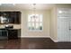 Charming eat-in kitchen features stainless appliances, dark cabinets, hardwood floors, and shutters at 7229 Terregles Dr, Raleigh, NC 27617