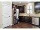 Modern kitchen boasts stainless appliances, dark cabinetry, and hardwood floors at 7229 Terregles Dr, Raleigh, NC 27617