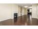 Open living room with hardwood floors and a fireplace, leading to the kitchen at 7229 Terregles Dr, Raleigh, NC 27617