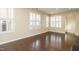 Open-concept living area with dark wood floors and natural light from shuttered windows at 7229 Terregles Dr, Raleigh, NC 27617