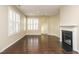 Spacious living room with hardwood floors and a fireplace, brightened by shuttered windows at 7229 Terregles Dr, Raleigh, NC 27617