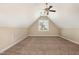 A neutral attic room includes carpeting, a window, and light-colored walls at 7940 Milltrace Run, Raleigh, NC 27615