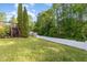 A large backyard has a wood deck, white fence, and plenty of green trees at 7940 Milltrace Run, Raleigh, NC 27615