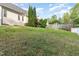 A green backyard has a white fence, a deck, and green trees at 7940 Milltrace Run, Raleigh, NC 27615
