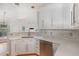 Well-lit kitchen with white cabinetry, stainless steel appliances, and hardwood floors with eat-in nook at 7940 Milltrace Run, Raleigh, NC 27615