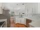 Well-lit kitchen with white cabinetry, stainless steel appliances, and hardwood floors with eat-in nook at 7940 Milltrace Run, Raleigh, NC 27615