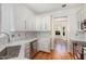 Modern kitchen featuring white cabinets, stainless steel appliances, and hardwood floors at 7940 Milltrace Run, Raleigh, NC 27615