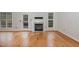 Bright living room featuring hardwood floors, a fireplace, and abundant natural light from multiple windows at 7940 Milltrace Run, Raleigh, NC 27615
