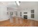 Open-concept living space with hardwood floors, a fireplace, and a seamless flow to the kitchen at 7940 Milltrace Run, Raleigh, NC 27615