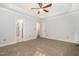 Light filled bedroom with neutral carpet, tray ceiling, ceiling fan, and ensuite bathroom at 7940 Milltrace Run, Raleigh, NC 27615