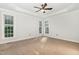 Spacious bedroom with neutral carpet, tray ceiling, ceiling fan and large windows at 7940 Milltrace Run, Raleigh, NC 27615