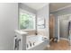 Relaxing bathroom features large tub, decorative window, and glass enclosed shower at 84 N Hadrian Ct, Clayton, NC 27520