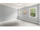 Clean bedroom with two windows, neutral paint, outlets, and gray carpet at 84 N Hadrian Ct, Clayton, NC 27520
