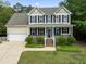 Charming two-story home with a manicured lawn and inviting front porch at 84 N Hadrian Ct, Clayton, NC 27520