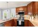 Elegant kitchen featuring granite countertops, stainless appliances, and wood cabinets at 84 N Hadrian Ct, Clayton, NC 27520