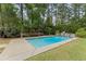 Refreshing backyard pool featuring a waterfall, lounge, and mature trees at 84 N Hadrian Ct, Clayton, NC 27520