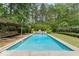 An inviting swimming pool with a charming waterfall feature and surrounding greenery at 84 N Hadrian Ct, Clayton, NC 27520