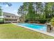 Backyard pool featuring a waterfall, outdoor seating, and mature trees at 84 N Hadrian Ct, Clayton, NC 27520