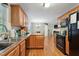 Functional kitchen featuring ample wood cabinetry, black appliances, and seamless flow to dining area at 8401 Hobhouse Cir, Raleigh, NC 27615
