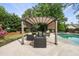 Backyard featuring a covered pergola and in-ground pool surrounded by lush greenery for the ultimate outdoor living at 101 Conway Ct, Cary, NC 27513