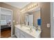 Bright bathroom featuring double sinks, large mirror with vanity lighting and view into adjacent bedroom at 101 Conway Ct, Cary, NC 27513