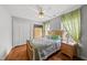Inviting bedroom features hardwood floors, a ceiling fan, and two bright windows at 101 Conway Ct, Cary, NC 27513
