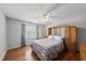 Cozy bedroom features hardwood floors, a ceiling fan, and a large window at 101 Conway Ct, Cary, NC 27513