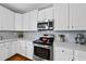 Modern kitchen featuring stainless steel appliances, white cabinets, and sleek gray countertops at 101 Conway Ct, Cary, NC 27513