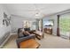 Bright living room with a comfortable sofa, a ceiling fan, and a large window, offering natural light and a cozy feel at 101 Conway Ct, Cary, NC 27513